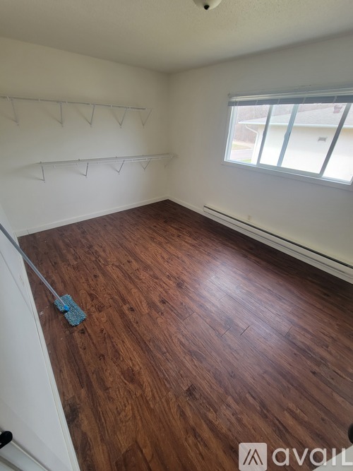A room with wooden flooring and a window.