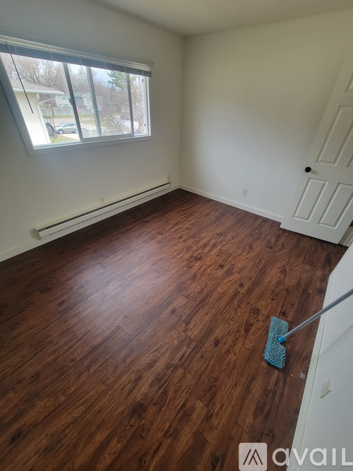 A room with wooden flooring and a window.