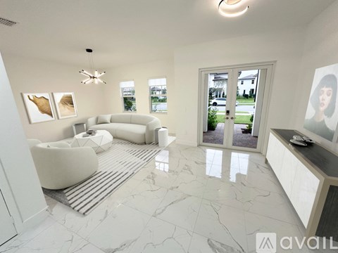 A spacious living room with a white sofa set and a television.