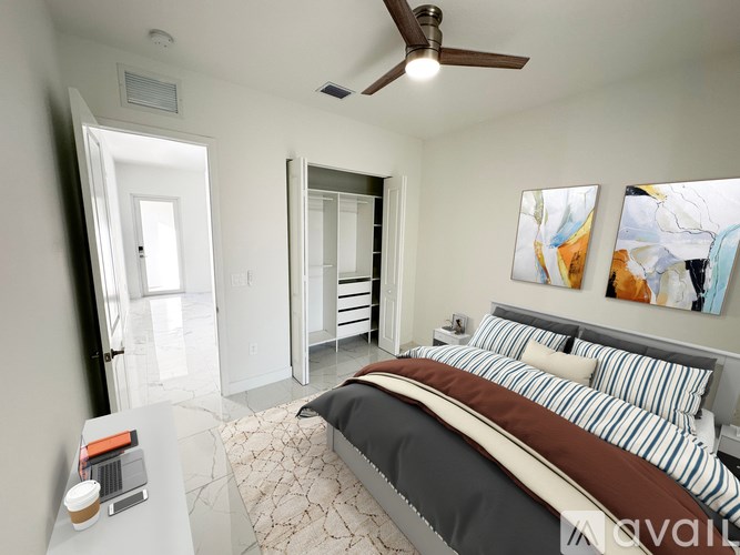 A bedroom with a large bed and a ceiling fan.
