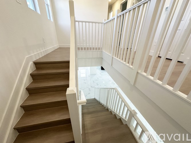 A staircase with white railings and wooden steps.