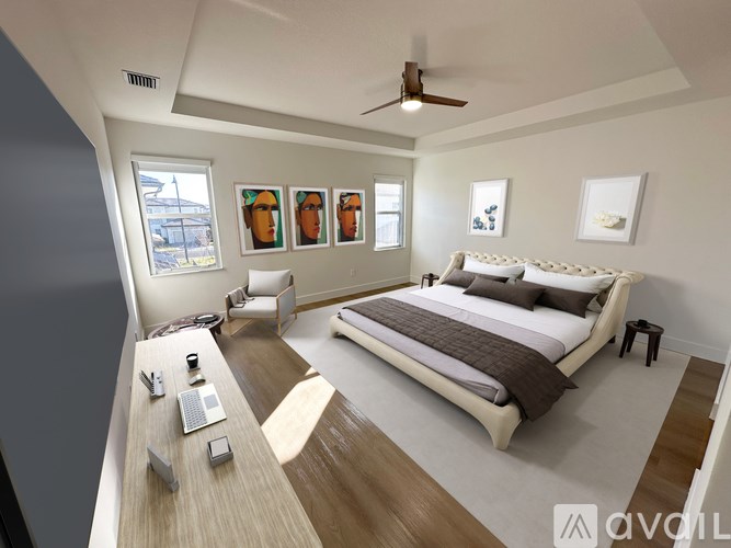A bedroom with a large bed, a desk with a laptop, and a ceiling fan.