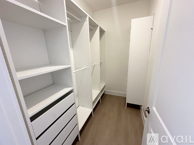 A white walk-in closet with shelves and drawers.