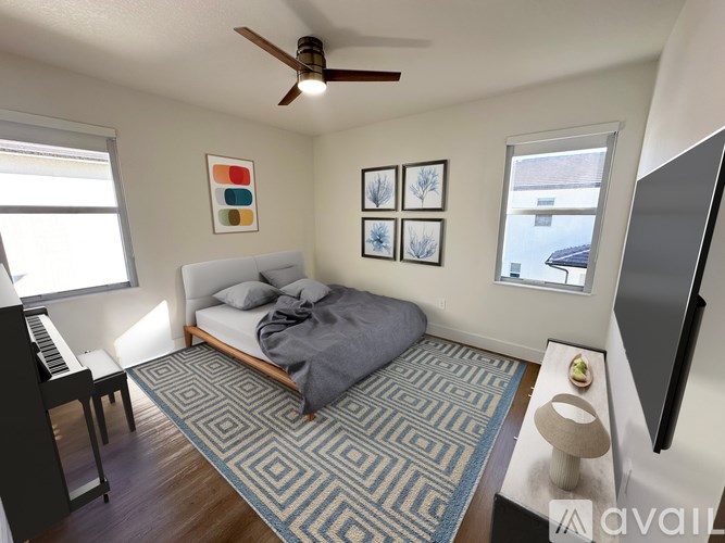 A bedroom with a bed, a piano, a ceiling fan, and a rug.
