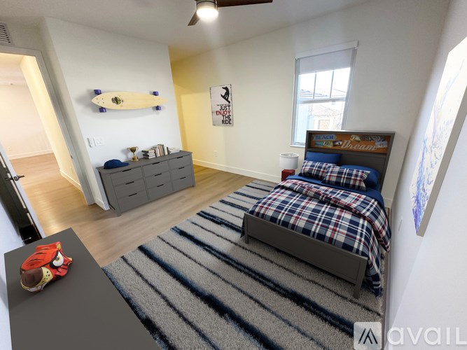 A bedroom with a bed, dresser, and a surfboard on the wall.