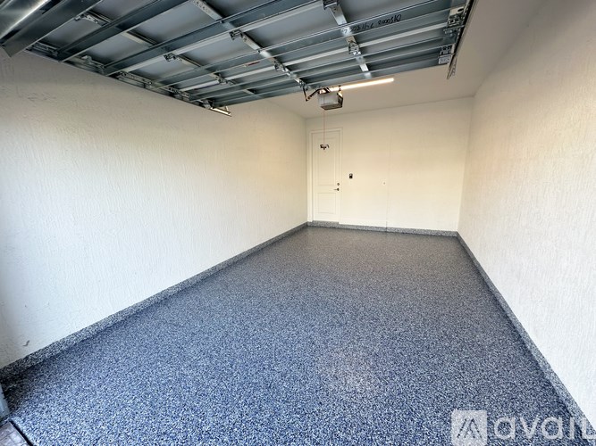 A room with a blue carpet and a ceiling with metal beams.