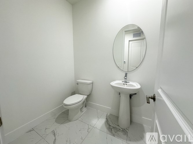 A bathroom with a toilet, sink and mirror.