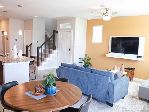 A living room with a blue couch and a wooden table.