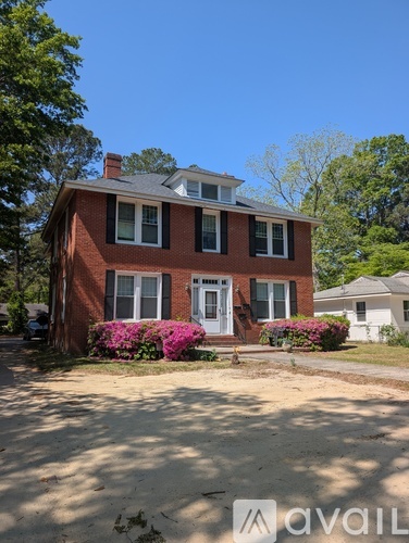 A red brick house with a white door and windows.