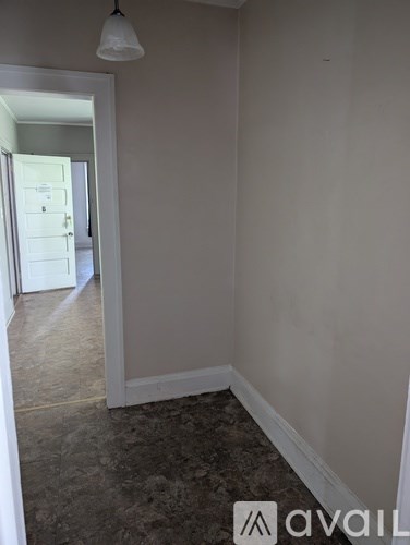 A room with a carpeted floor and a doorway leading to another room.