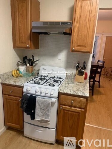 A kitchen with a white stove and wooden cabinets.