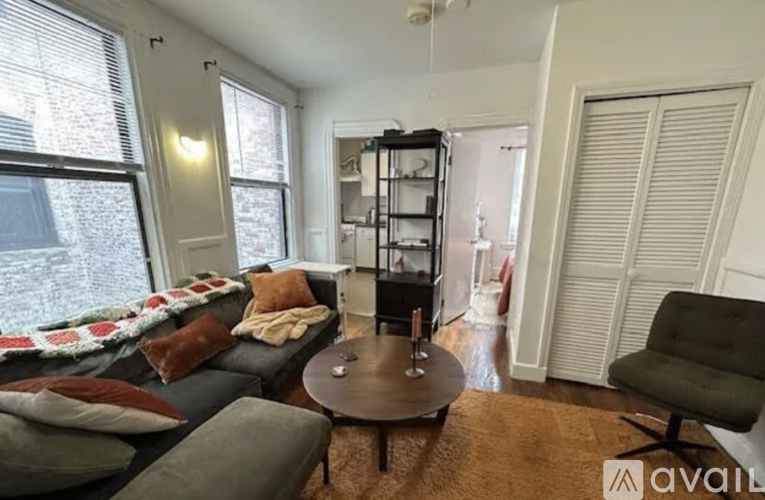 A living room with a grey couch, a coffee table, and a green chair.