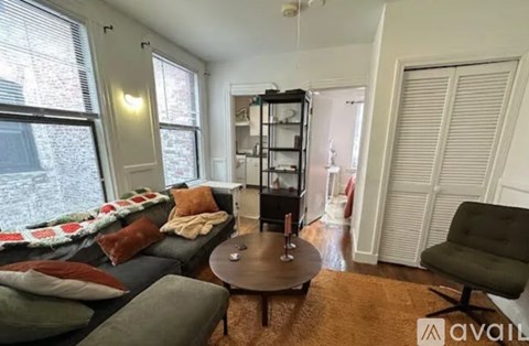 A living room with a grey couch, a coffee table, and a green chair.