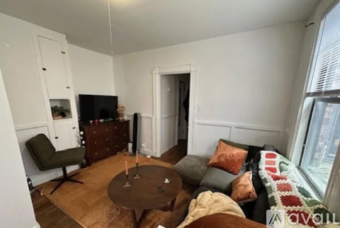 A living room with a brown table and a grey couch.