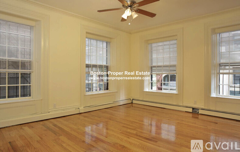 A room with wooden floors and a ceiling fan.