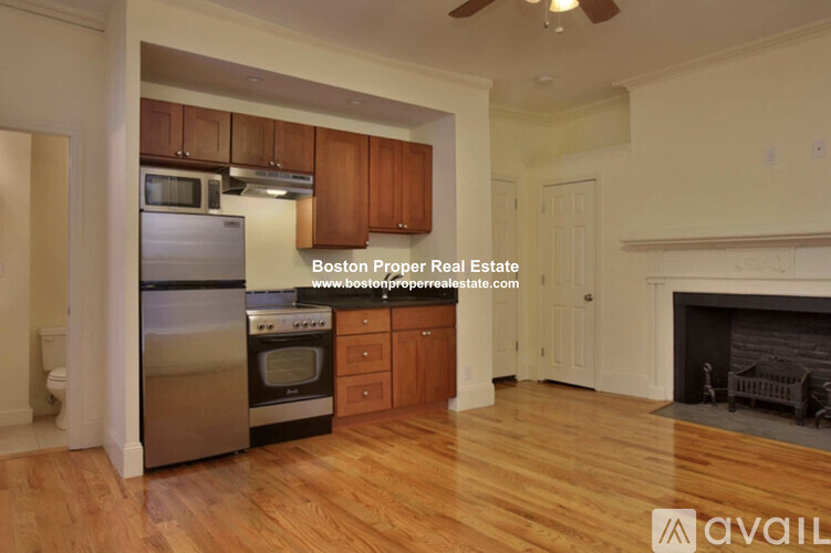 A kitchen with wooden cabinets and a stainless steel refrigerator.