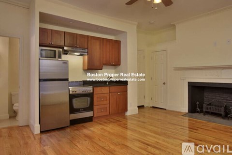 A kitchen with wooden cabinets and a stainless steel refrigerator.