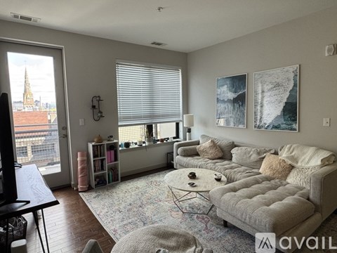 A living room with a large window and a view of a cityscape.