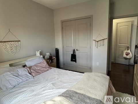A bedroom with a bed, nightstand, and a chandelier.