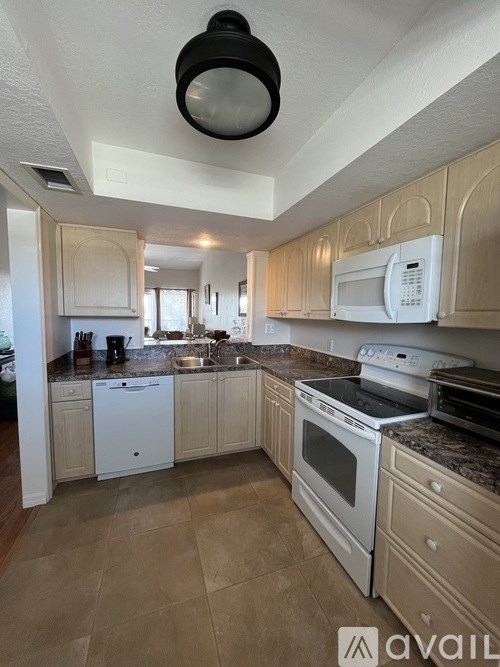 A kitchen with white appliances and wooden cabinets.
