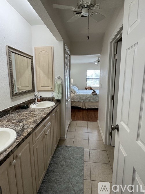 A bathroom with a marble countertop and a fan.