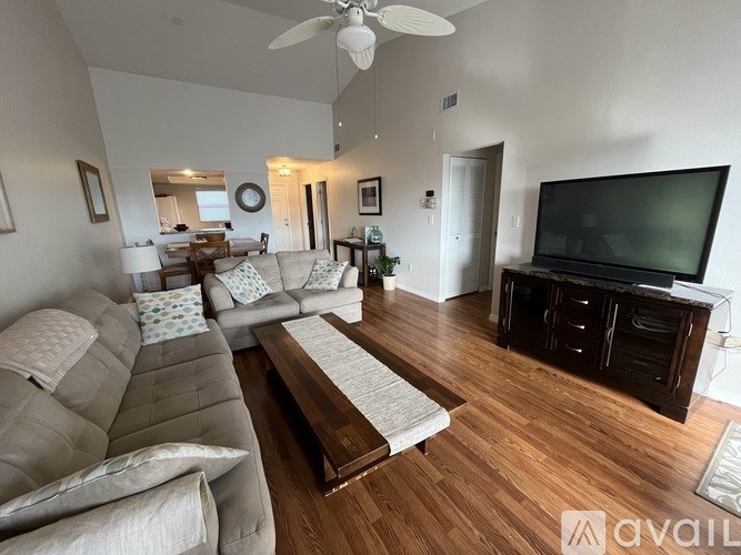 A living room with a grey couch and a wooden floor.