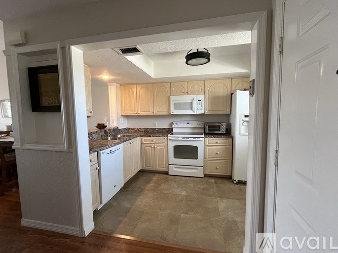 A kitchen with white cabinets and appliances is shown.