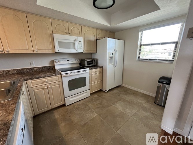 A kitchen with a white fridge and a white microwave above the stove.