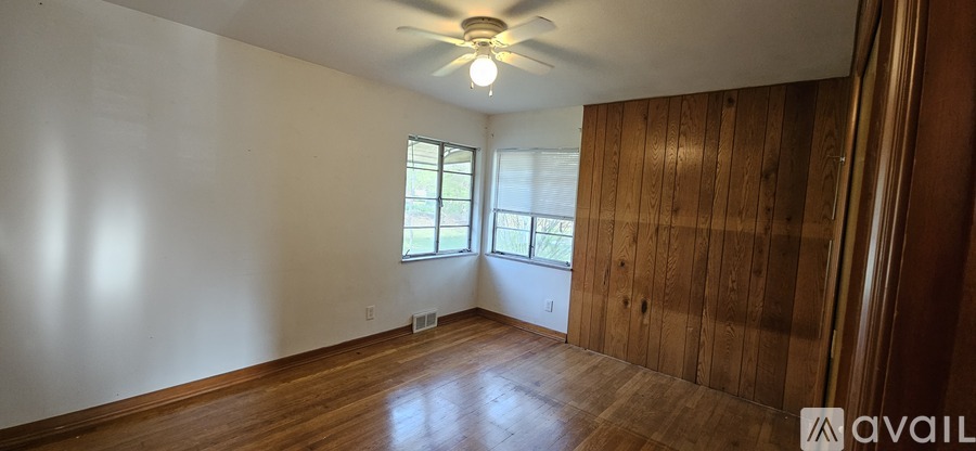 A room with wooden walls and a ceiling fan.