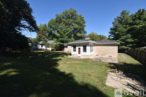 A house with a yard and trees in the background.