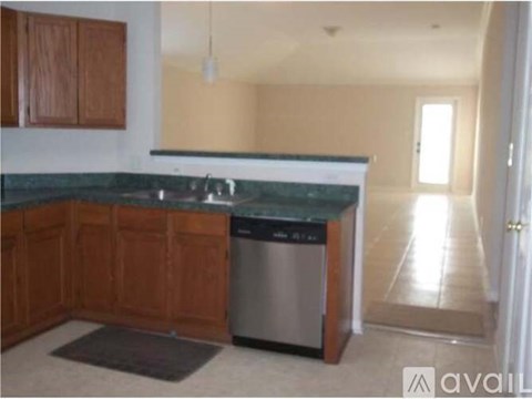 A kitchen with wooden cabinets and a granite countertop.