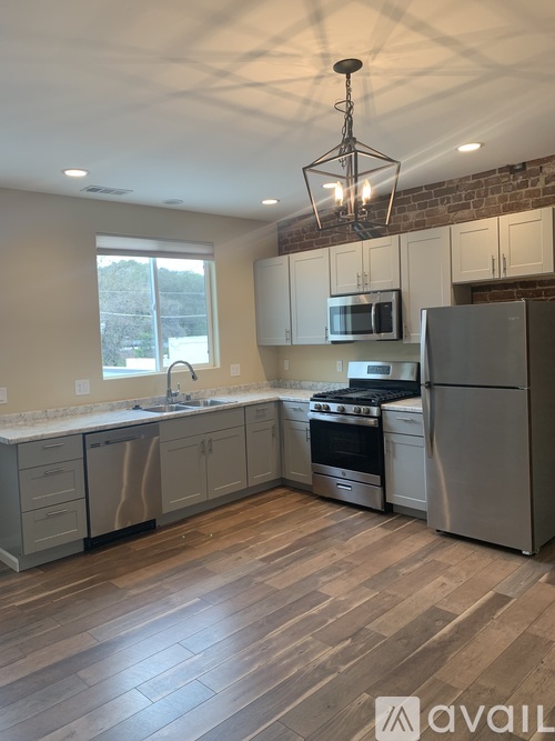 A kitchen with wooden floors and stainless steel appliances.