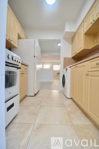 A kitchen with white appliances and wooden cabinets.