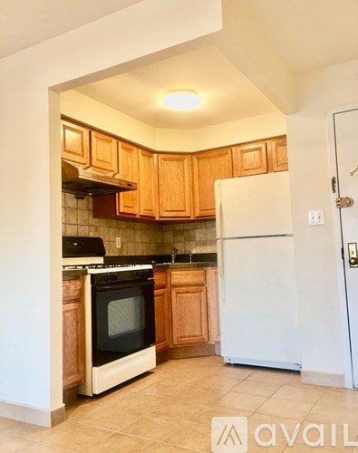 A kitchen with wooden cabinets and a white refrigerator.