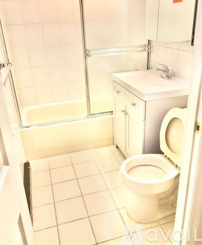 A white toilet in a small bathroom with a walk-in shower.