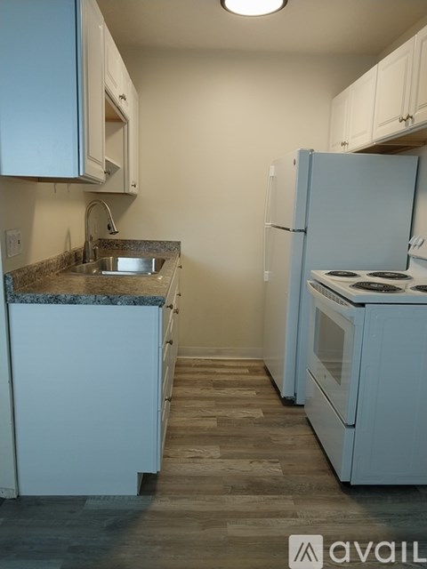 A kitchen with a blue refrigerator and white cabinets.