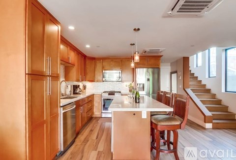 A kitchen with wooden cabinets and a white island.