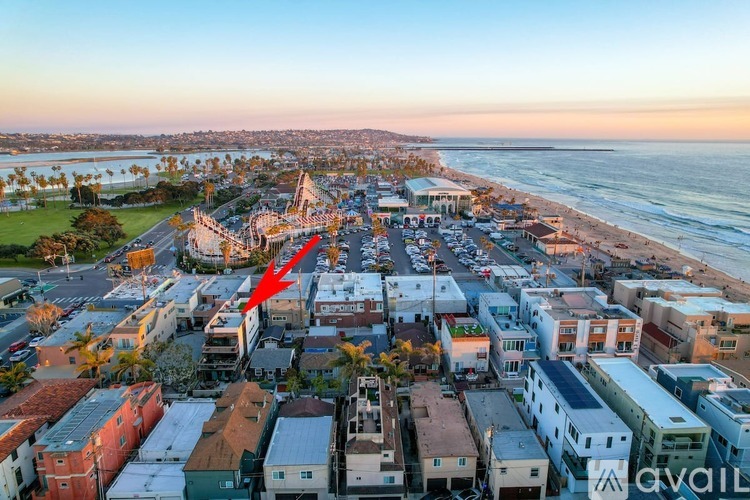 A red arrow points to a building in a beachfront neighborhood.