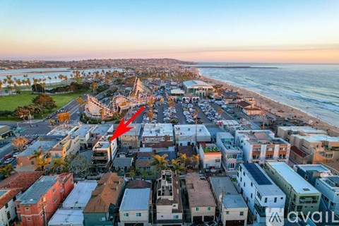 A red arrow points to a building in a beachfront neighborhood.