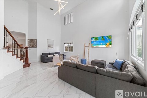 A living room with a grey sofa and a painting on the wall.