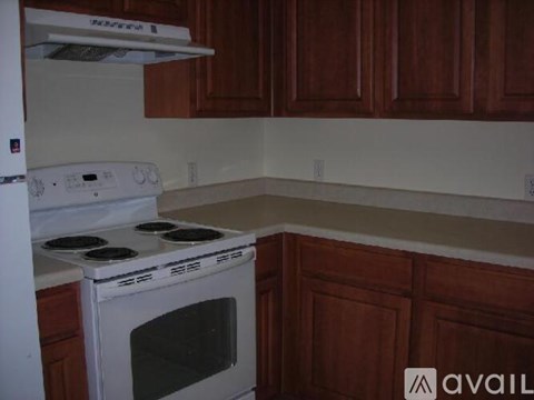 A white stove and oven in a kitchen with wooden cabinets.