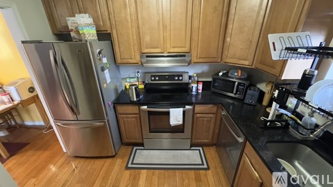 A kitchen with wooden cabinets and a stainless steel refrigerator.