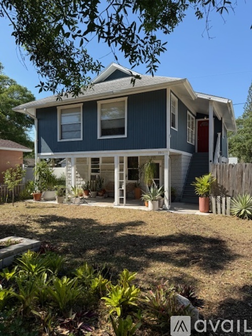 A blue house with a red door and a porch.