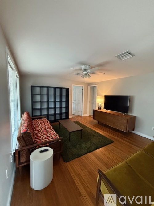 A living room with a sofa, a coffee table, and a television.