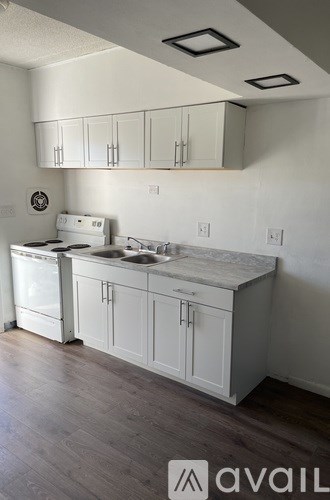 A kitchen with white cabinets and a marble countertop.