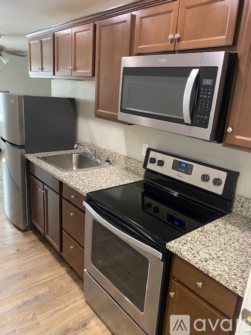 A kitchen with a black stove top oven and a black microwave above it.