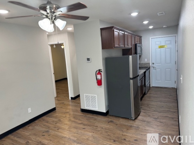 A kitchen with a refrigerator, microwave, and oven.