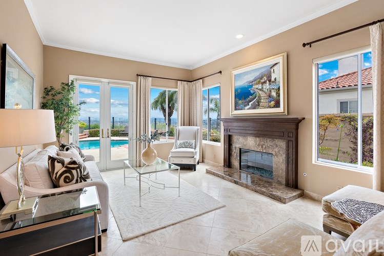 A living room with a fireplace and a view of the pool outside.