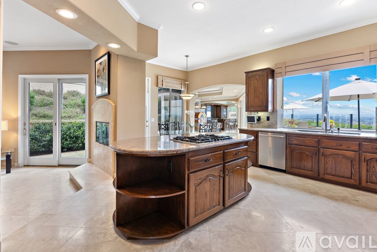A spacious kitchen with a large island and wooden cabinets.