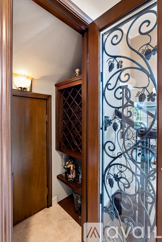 A wooden cabinet with a glass door and a wine rack inside.
